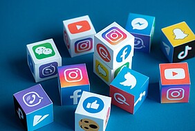 Social Media als Wuerfel-Icons auf blauem Hintergrund